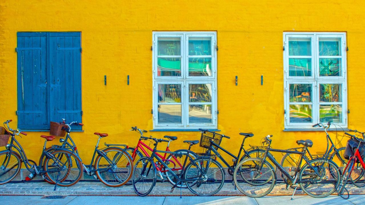 Designhotel Kopenhagen Motel One mehrere Fahrräder vor einer gelben Hauswand