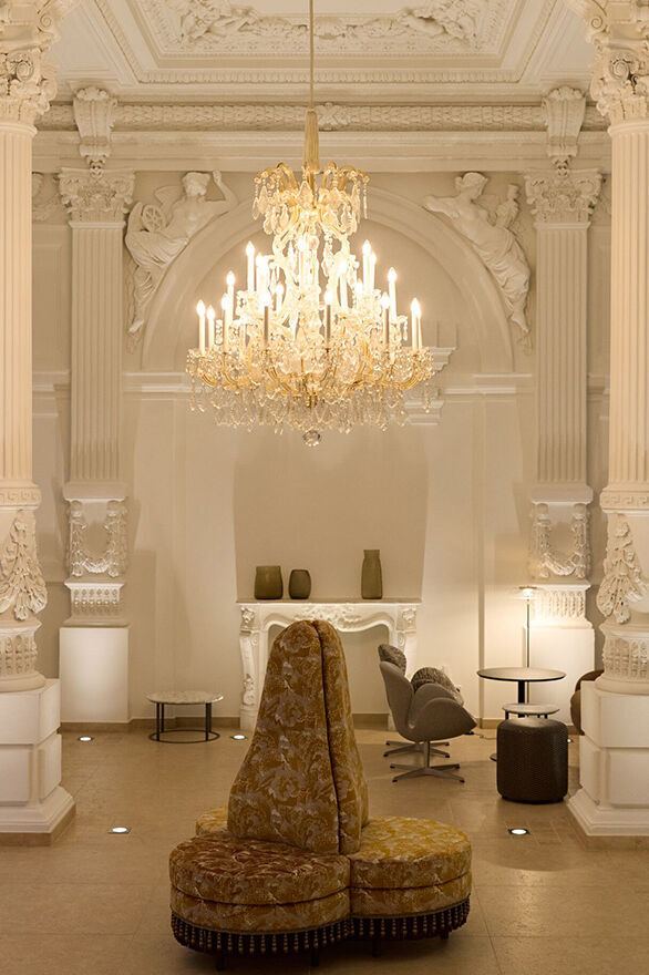 Prächtiger, historisch gestalteter Innenraum mit hoher Stuckdecke, verzierten Säulen und elegantem Kronleuchter. Gemütliche Sitzmöbel laden zum Entspannen ein. Atmosphäre verbindet klassische Pracht mit modernem Komfort. Prächtiger, historisch gestalteter Innenraum mit hoher Stuckdecke, verzierten Säulen und elegantem Kronleuchter. Gemütliche Sitzmöbel laden zum Entspannen ein. Atmosphäre verbindet klassische Pracht mit modernem Komfort.