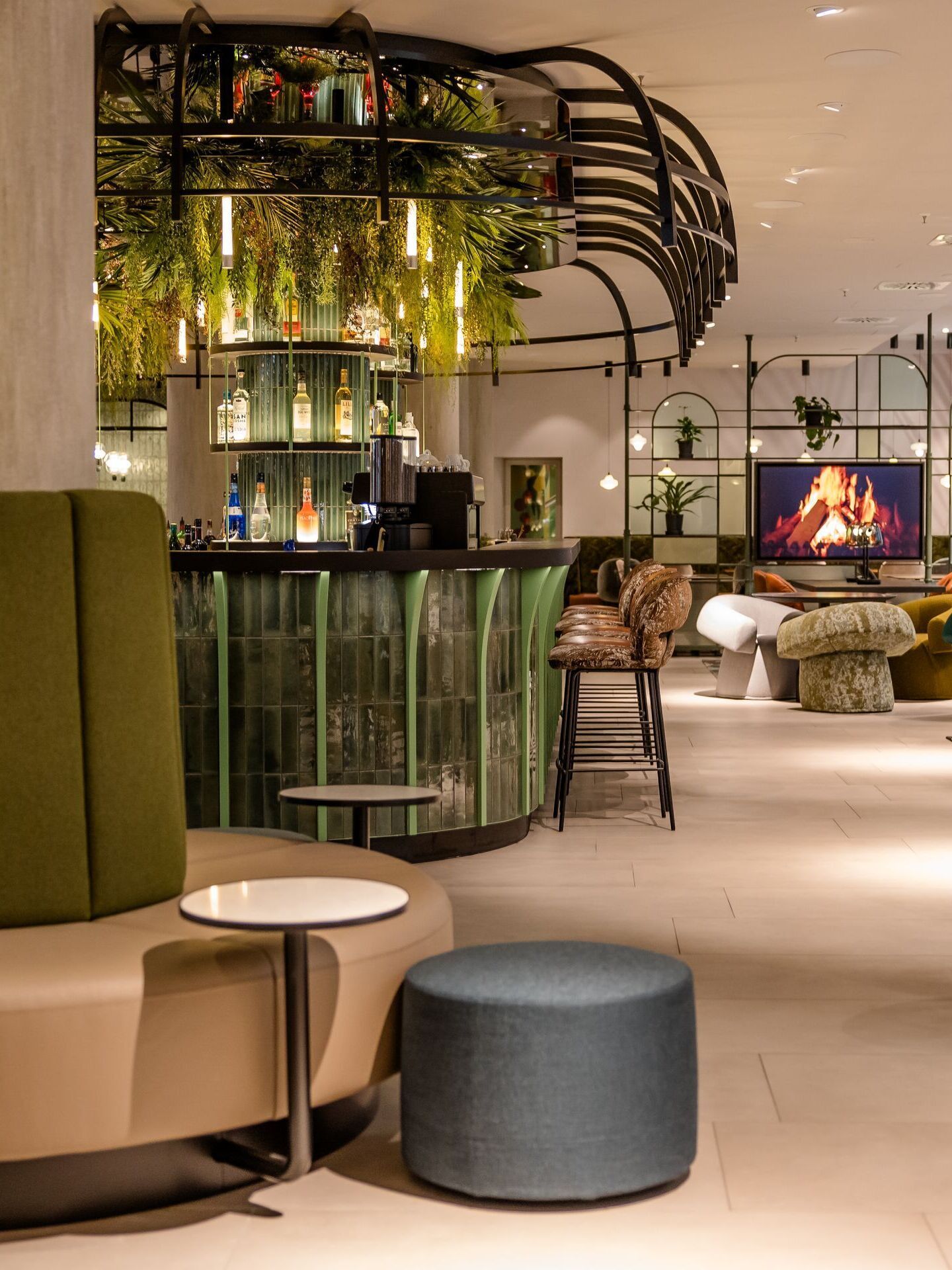 Hotel Frankfurt-Hauptbahnhof Motel One bright lounge with comfortable seating, bar, plant décor and a digital fireplace.