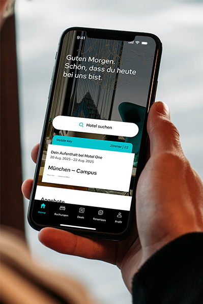 Hand hält Smartphone mit Hotel-App, zeigt Buchungsdetails für Motel One in München-Campus, inklusive Aufenthalt und Zimmernummer. Begrüßungstext „Guten Morgen, schön, dass du heute bei uns bist.“ sichtbar. Suchfunktion für Hotels ebenfalls dargestellt. Hand hält Smartphone mit Hotel-App, zeigt Buchungsdetails für Motel One in München-Campus, inklusive Aufenthalt und Zimmernummer. Begrüßungstext „Guten Morgen, schön, dass du heute bei uns bist.“ sichtbar. Suchfunktion für Hotels ebenfalls dargestellt.