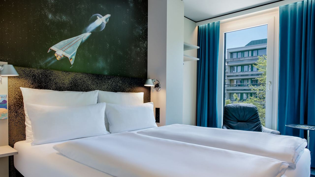 Designhotel Deutsches Museum Motel One lichtdurchflutetes Doppelzimmer mit komfortablem Bett und bodentiefen Fenstern
