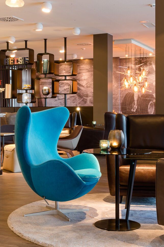 hotel Frankfurt Airport Motel One open lounge area with several armchairs, egg chair and bar area