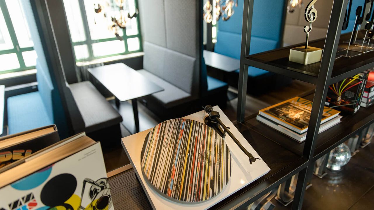 hotel Mannheim Motel One seating and open shelf with decoration in the form of a record player and sheet music