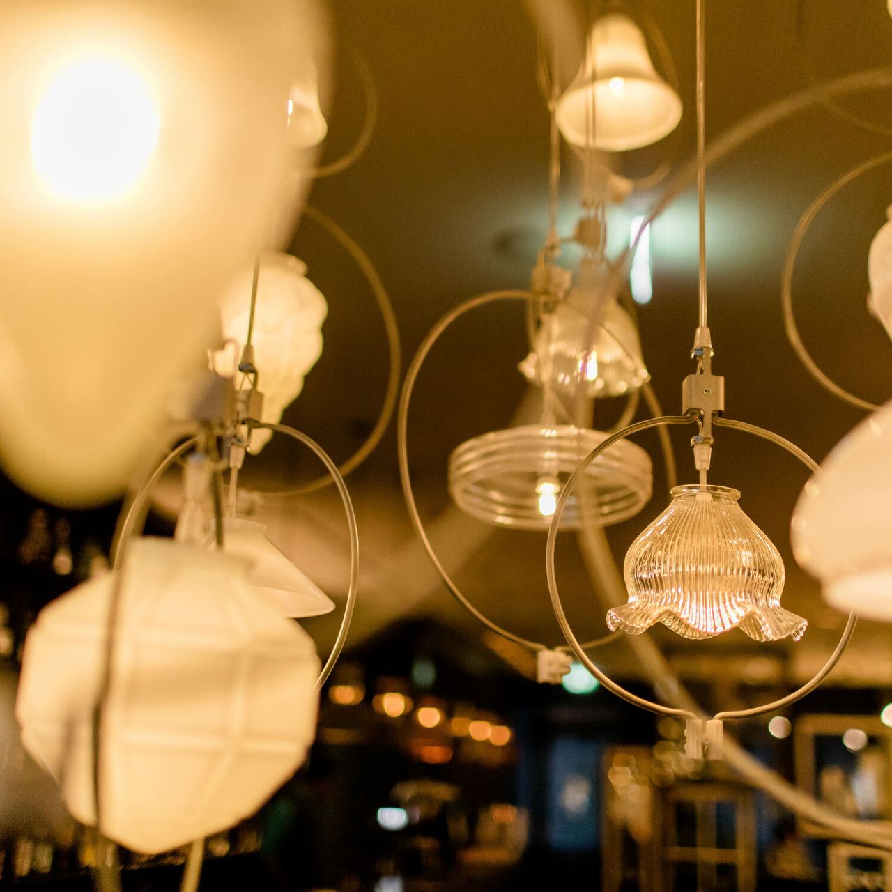 Hängende, dekorative Leuchten aus Glas und Papier verbreiten warmes, einladendes Licht