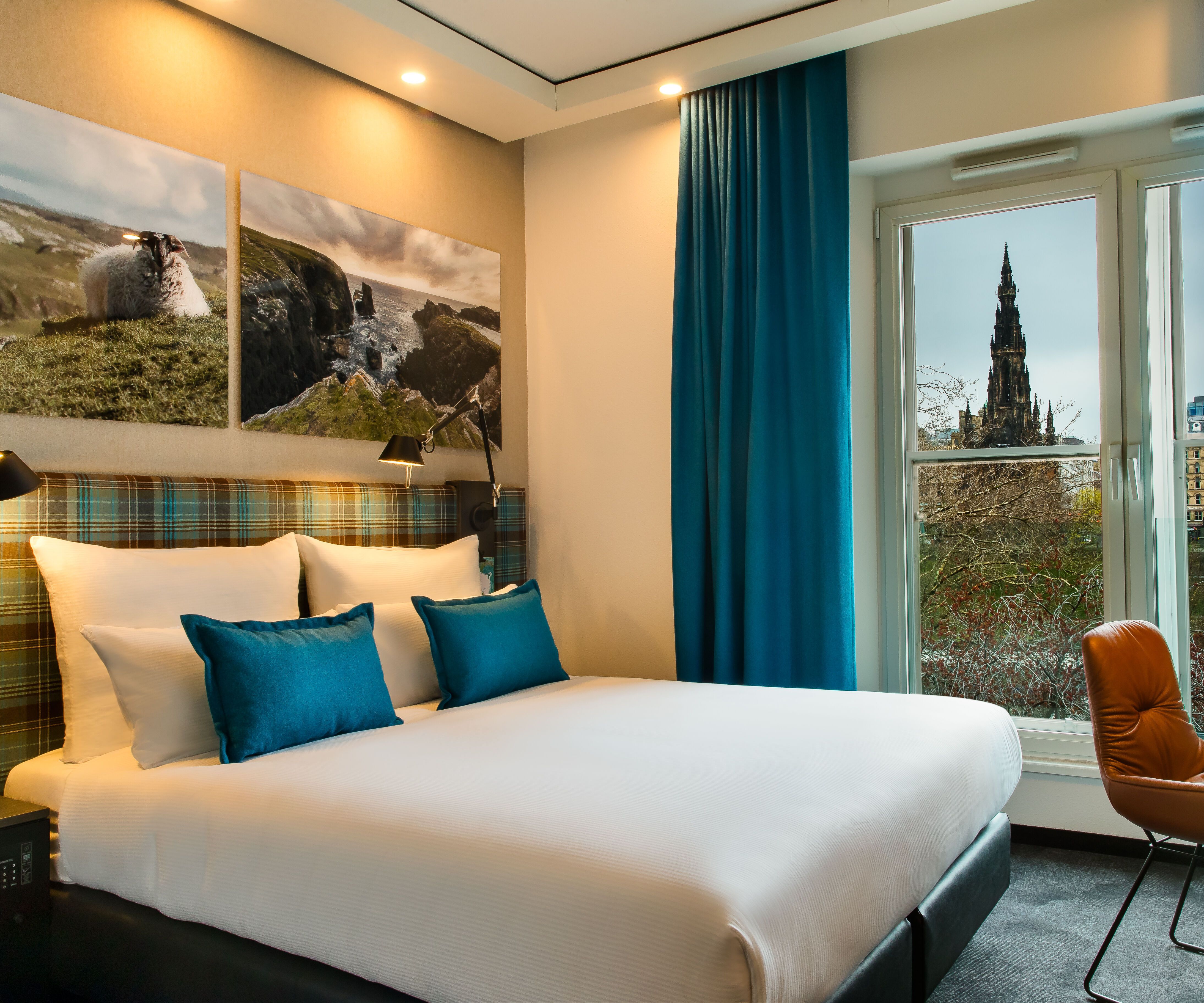 hotel Edinburgh Royal Motel One double bed with desk and chair and floor-to-ceiling window that provides plenty of light