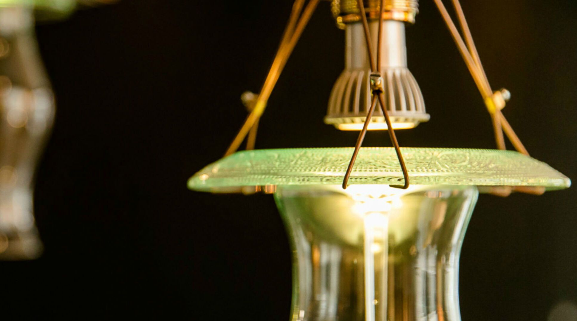 Nahaufnahme von stilvollen, hängenden Lampen mit warmem Licht vor dunklem Hintergrund