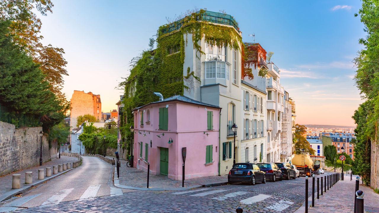 Malersisches Straßeneck in Montmartre, Paris, mit historischen Gebäuden, Kopfsteinpflaster und abendlicher Beleuchtung, die eine ruhige, charmante Atmosphäre vermittelt.