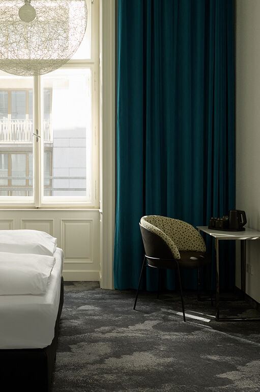 Modern eingerichtetes Hotelzimmer mit großem Fenster, dunklen Vorhängen, Doppelbett mit weißer Bettwäsche, Schreibtisch mit Stuhl und wandmontiertem Fernseher, ruhige und helle Atmosphäre. Modern eingerichtetes Hotelzimmer mit großem Fenster, dunklen Vorhängen, Doppelbett mit weißer Bettwäsche, Schreibtisch mit Stuhl und wandmontiertem Fernseher, ruhige und helle Atmosphäre.