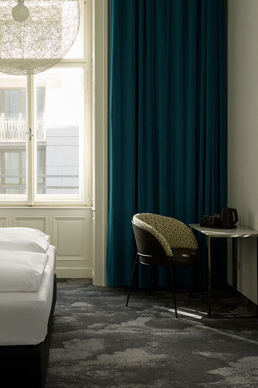 Modern eingerichtetes Hotelzimmer mit großem Fenster, dunklen Vorhängen, Doppelbett mit weißer Bettwäsche, Schreibtisch mit Stuhl und wandmontiertem Fernseher, ruhige und helle Atmosphäre. Modern eingerichtetes Hotelzimmer mit großem Fenster, dunklen Vorhängen, Doppelbett mit weißer Bettwäsche, Schreibtisch mit Stuhl und wandmontiertem Fernseher, ruhige und helle Atmosphäre.