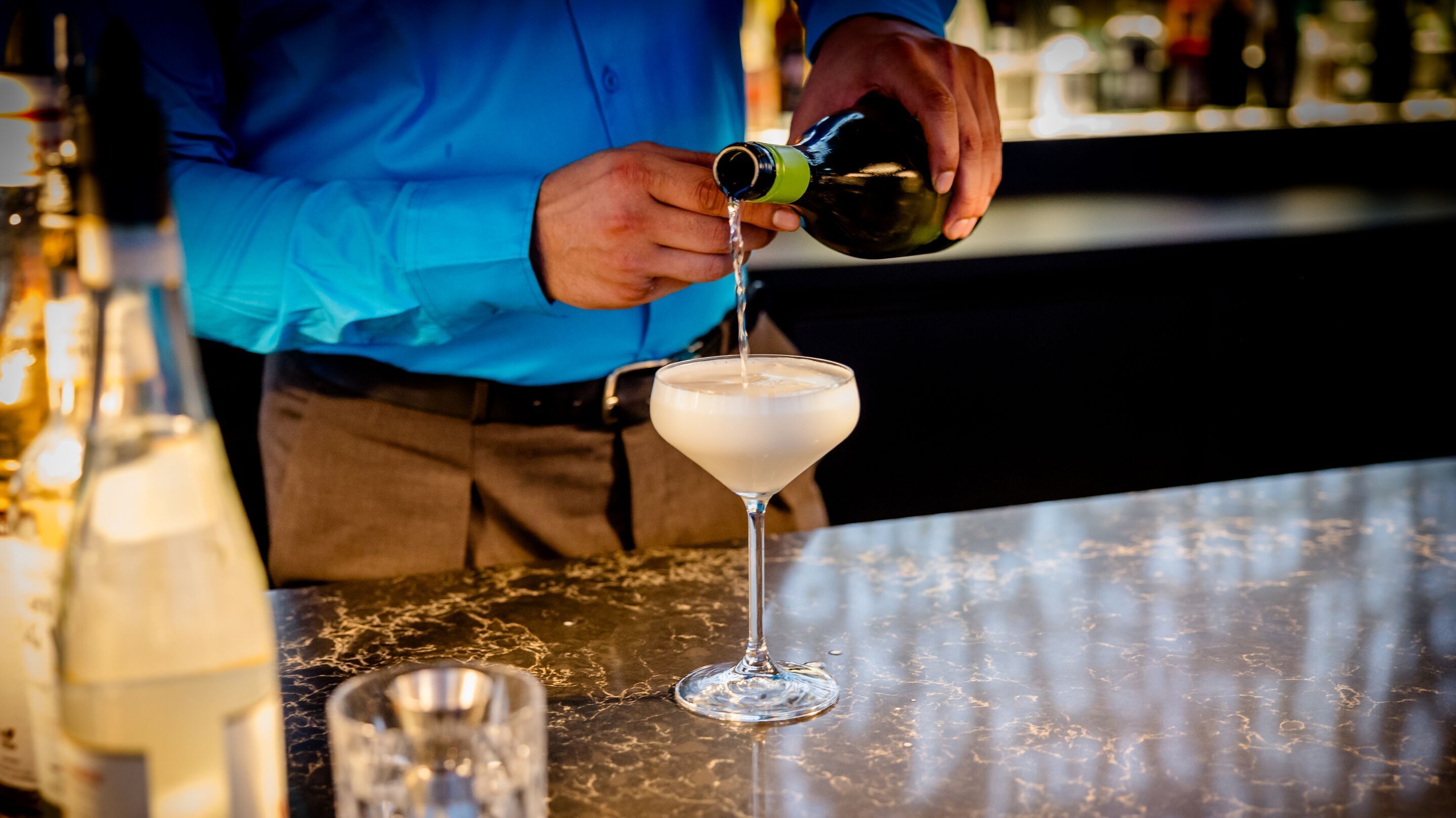 Hotel Karlsruhe Motel One Rooftop Bar mit Barkeeper, der den Signature Cocktail zubereitet.