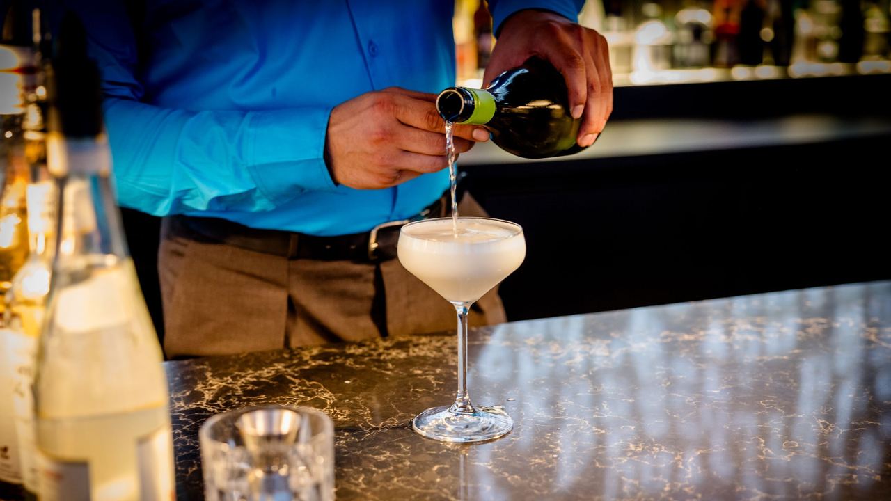 Hotel Karlsruhe Motel One Rooftop Bar mit Barkeeper, der den Signature Cocktail zubereitet.