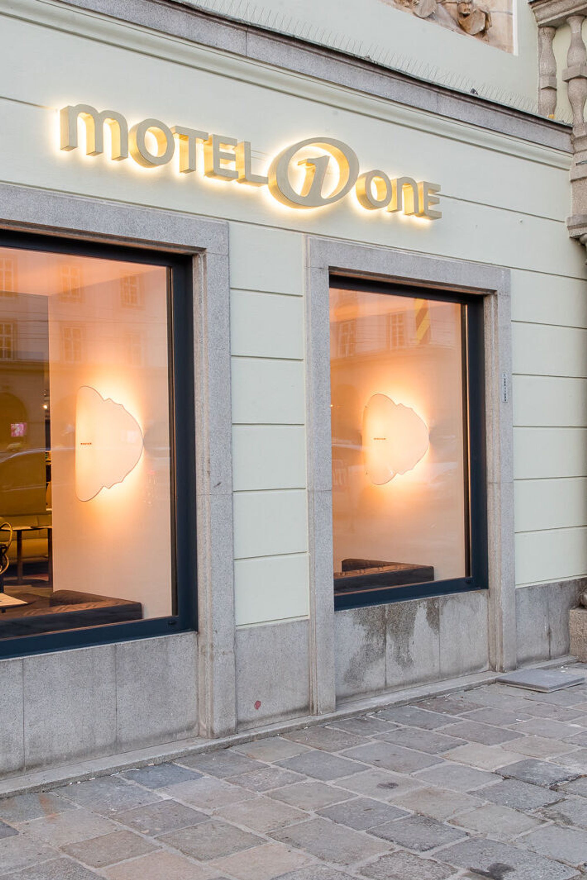 Hotel Linz Hauptplatz Motel One Blick auf den Eingangsbereich mit leuchtendem Logo
