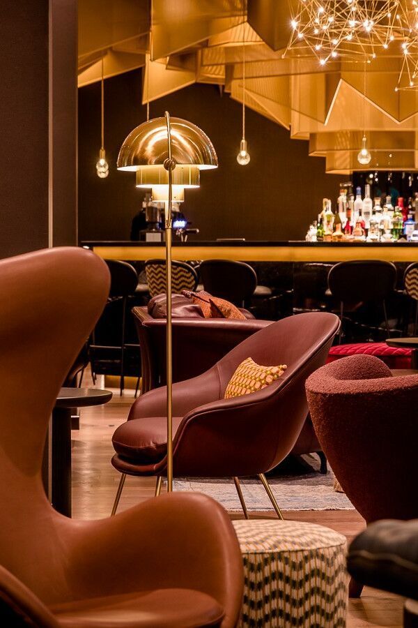 Stilvolle Motel One Hotelbar mit elegantem, gemütlichem Interieur, bequemen Sesseln und warmer Beleuchtung