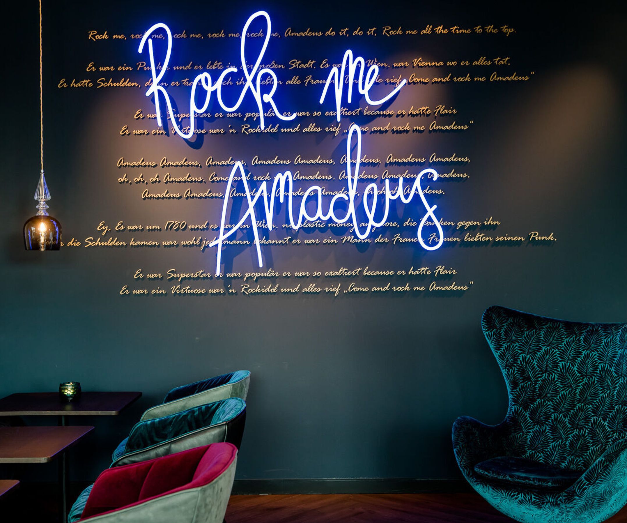 hotel Salzburg Mirabell Motel One lounge with eggchair and neon sign "Rock me Amadeus" on the wall