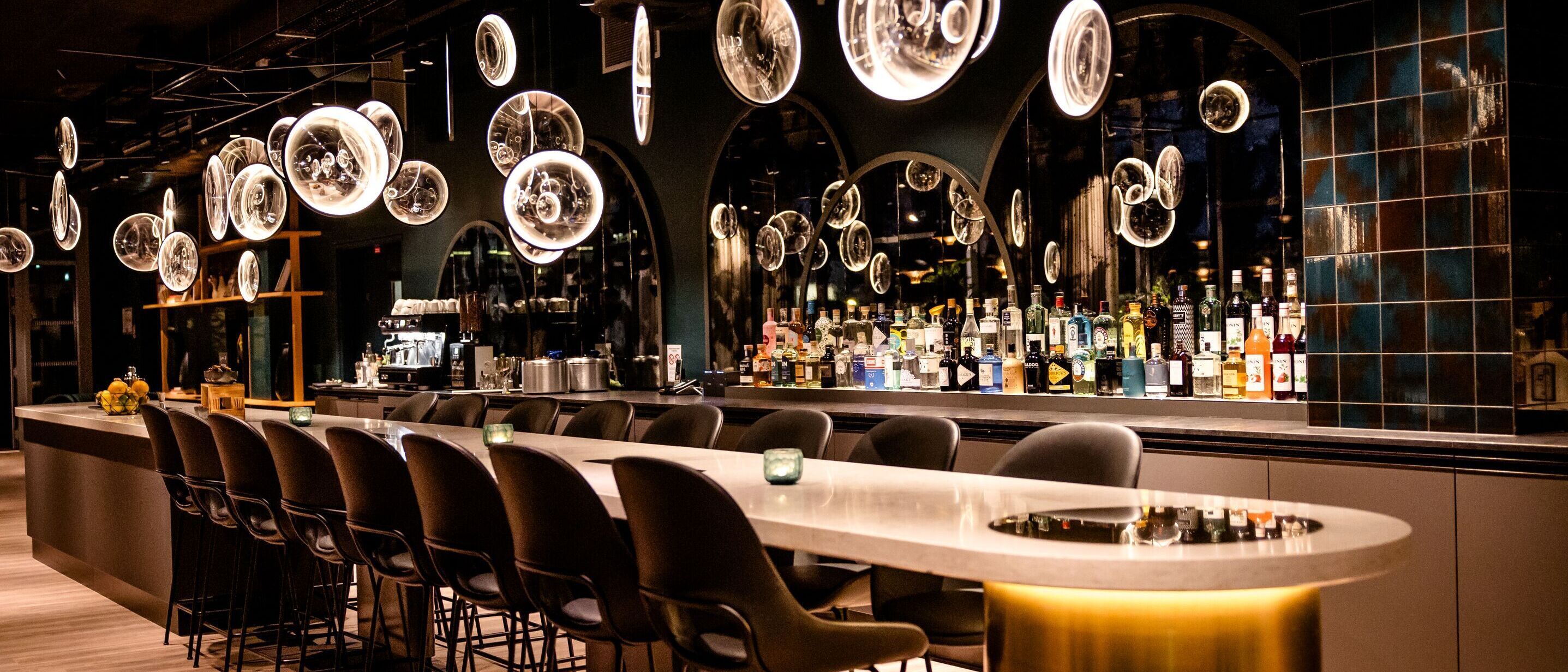 Designhotel Paris Porte de Versailles Motel One Bar mit langem Tisch und mehreren Stühlen