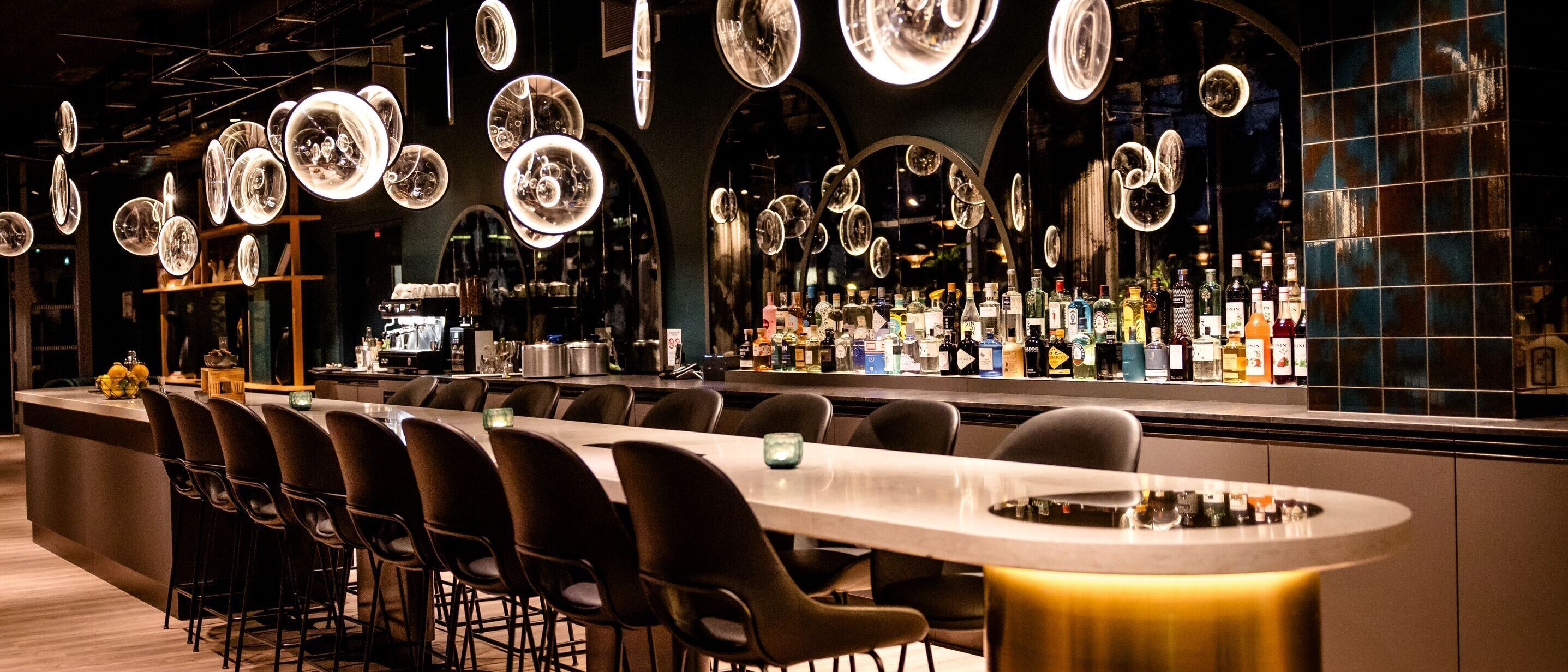 Designhotel Paris Porte de Versailles Motel One Bar mit langem Tisch und mehreren Stühlen