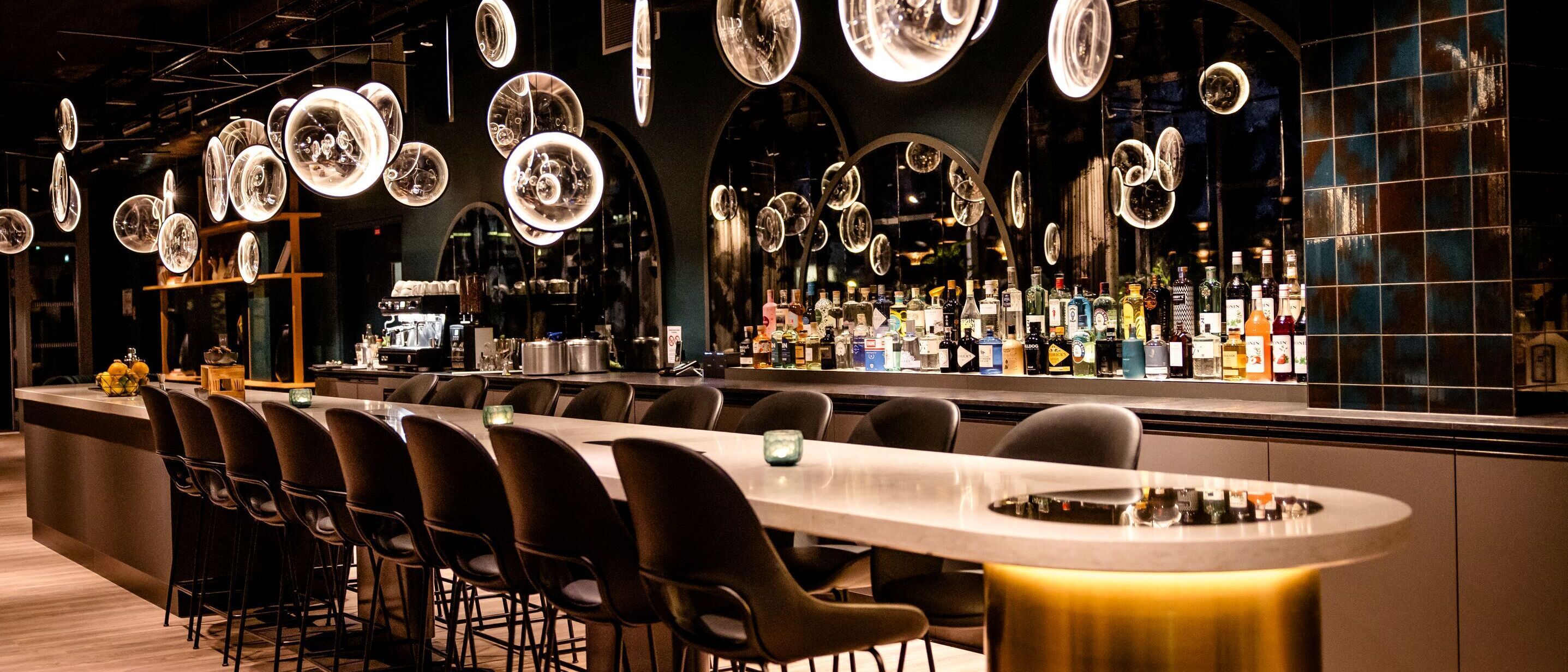 Designhotel Paris Porte de Versailles Motel One Bar mit langem Tisch und mehreren Stühlen