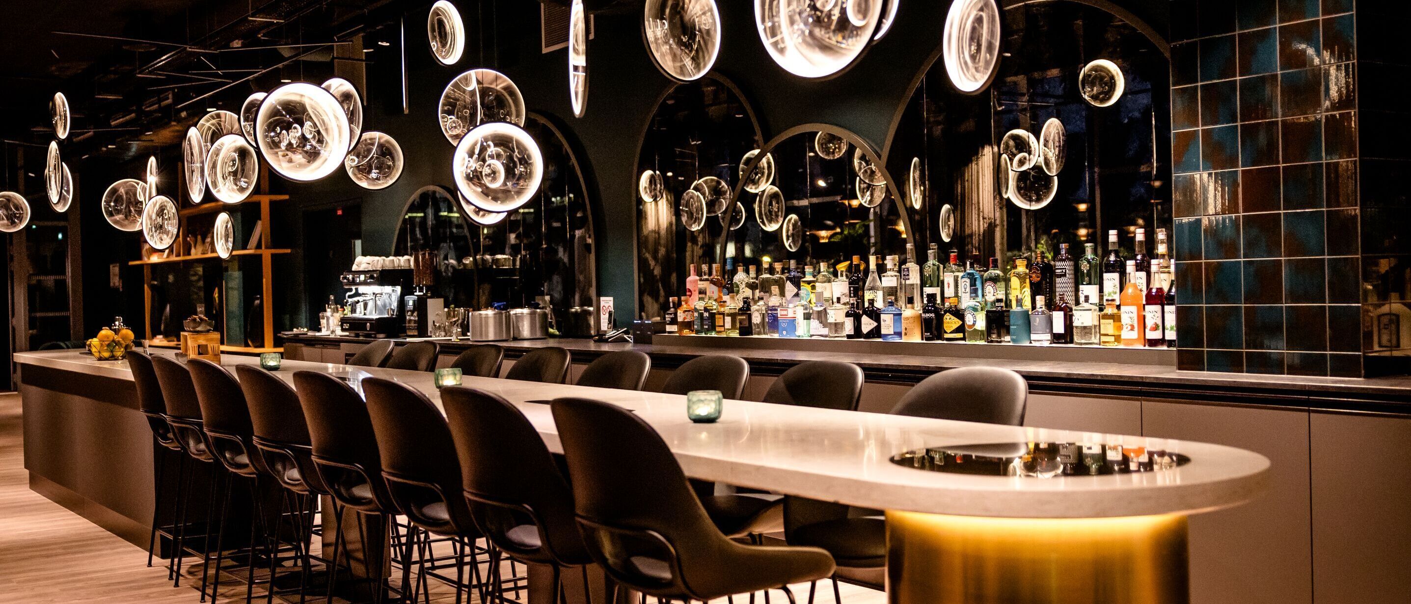 Designhotel Paris Porte de Versailles Motel One Bar mit langem Tisch und mehreren Stühlen