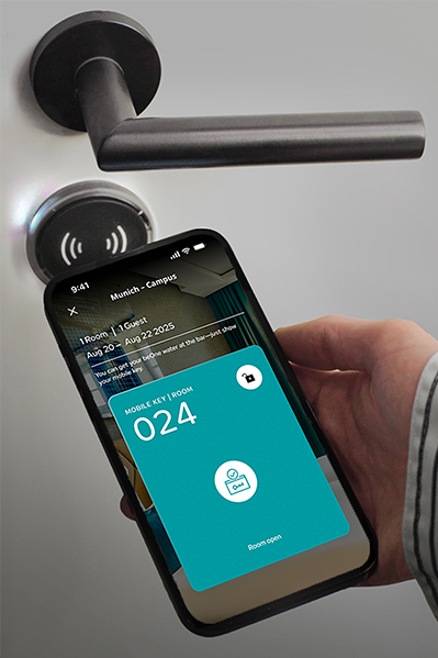 Person hält Smartphone mit digitalem Zimmerschlüssel vor elektronischen Türgriff, um Tür kontaktlos zu öffnen. Person hält Smartphone mit digitalem Zimmerschlüssel vor elektronischen Türgriff, um Tür kontaktlos zu öffnen.